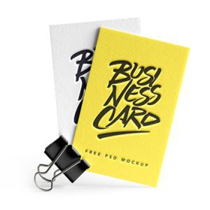 A mockup of two business cards held together by a black binder clip. The top card is yellow with the text "Business Card" in a bold, stylized black font, and the bottom card is white with the same text. The bottom text states, "Free PSD Mockup.